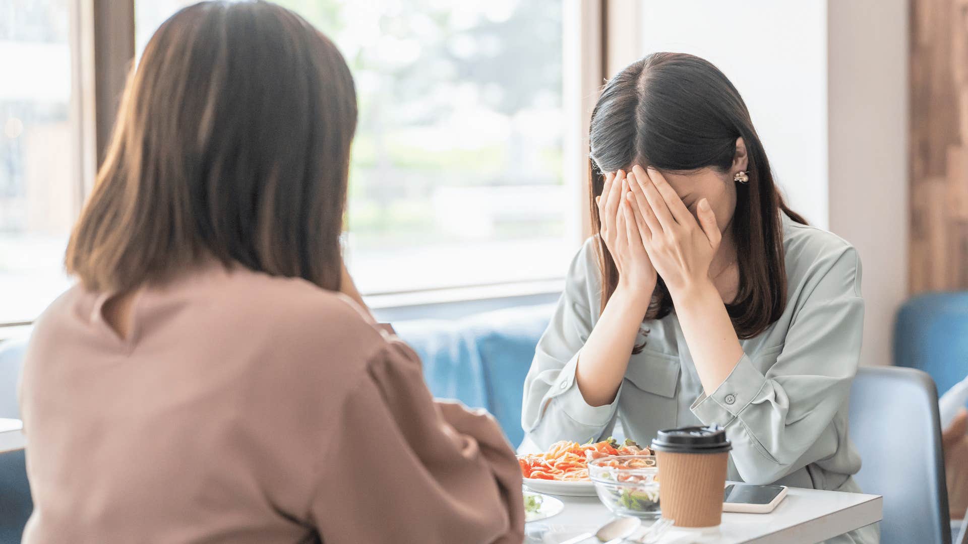 woman covering her face as she tells friend i didn't' have a choice