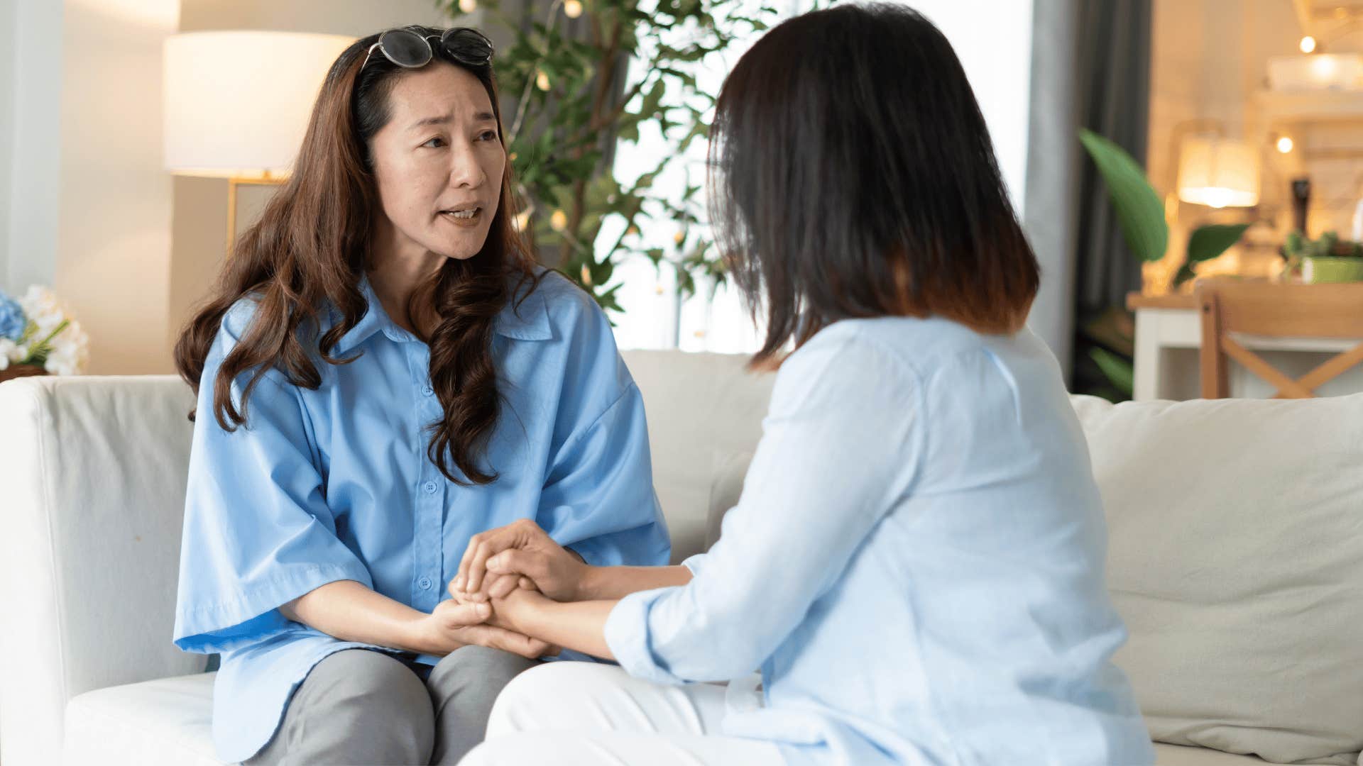 friend holding woman's hand as she says i don't mean to be harsh but