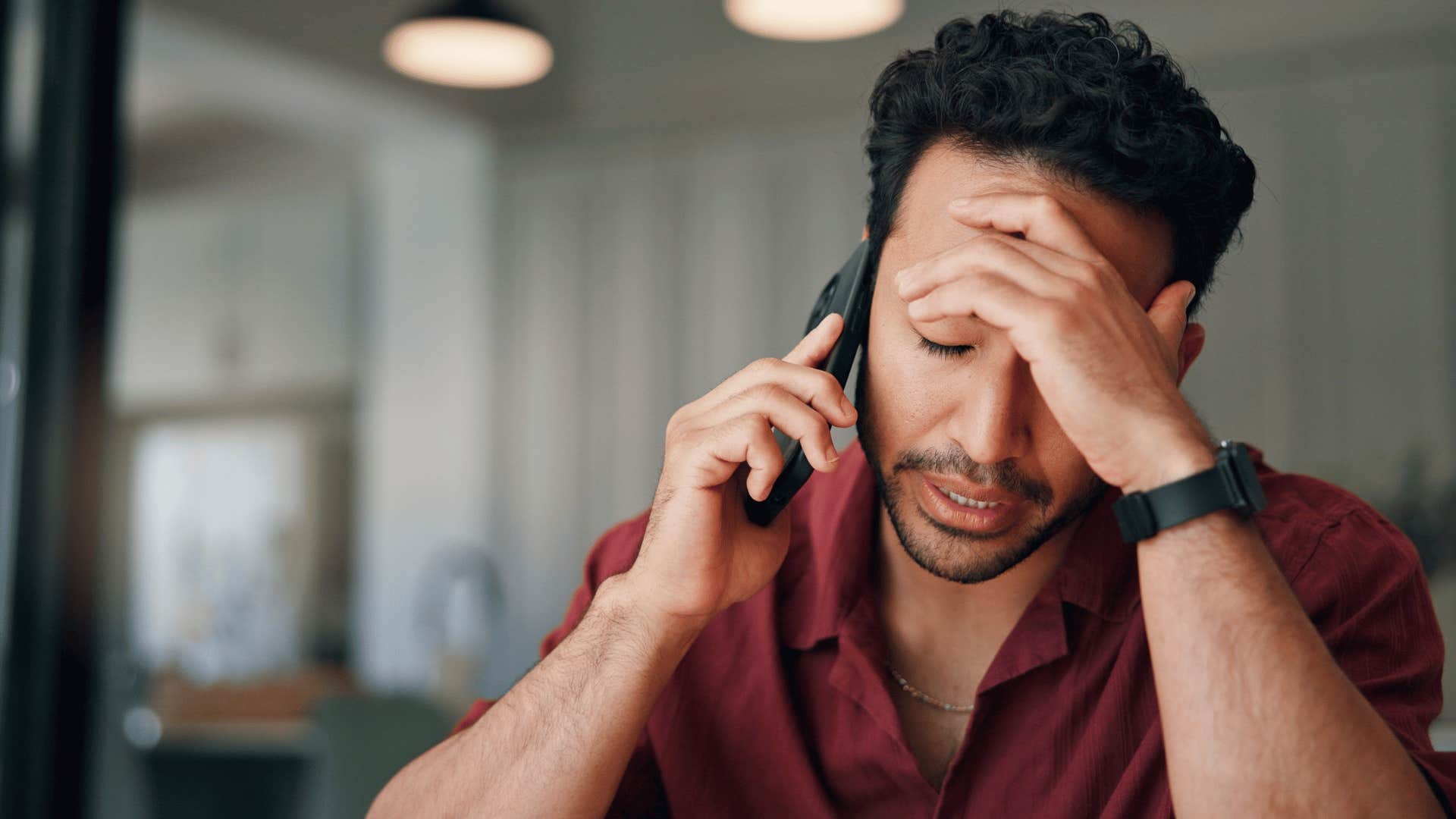 man in red shirt on the phone saying i'll pay them back when i get paid