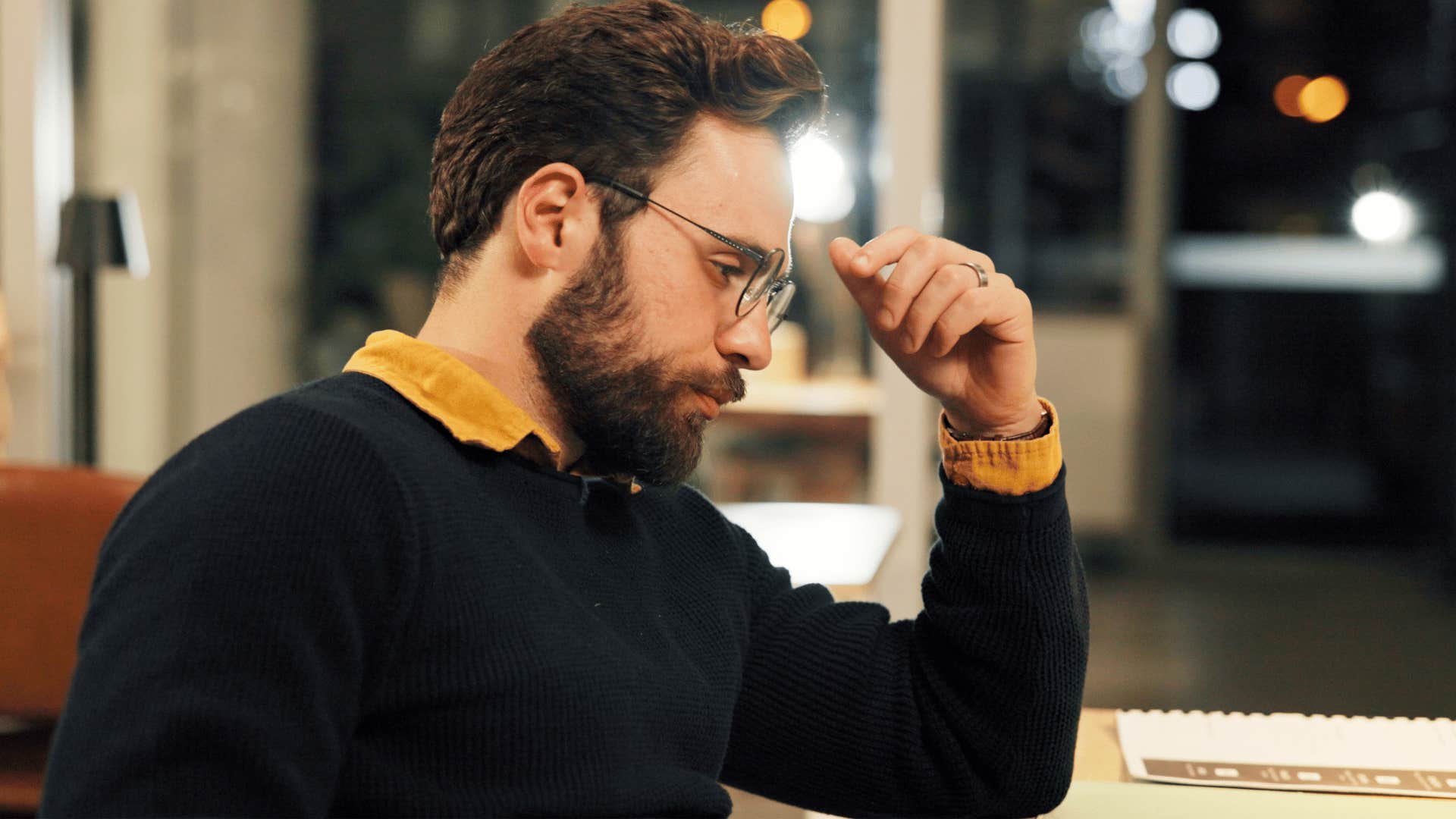 man in black sweater anxious as he thinks i'm just trying to get through this month