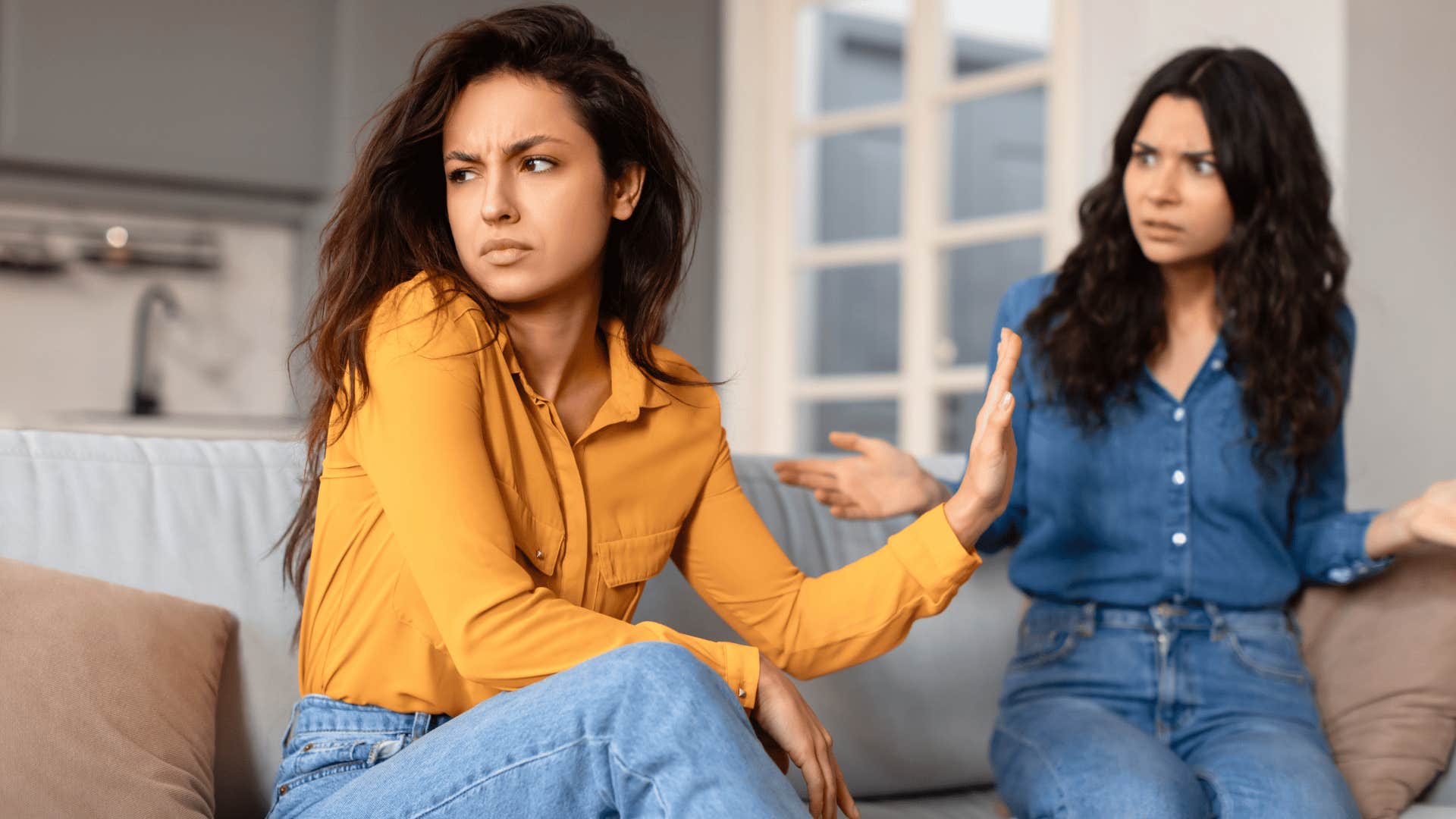 woman holding up hand to friend as she tells her an apology doesn't really change anything