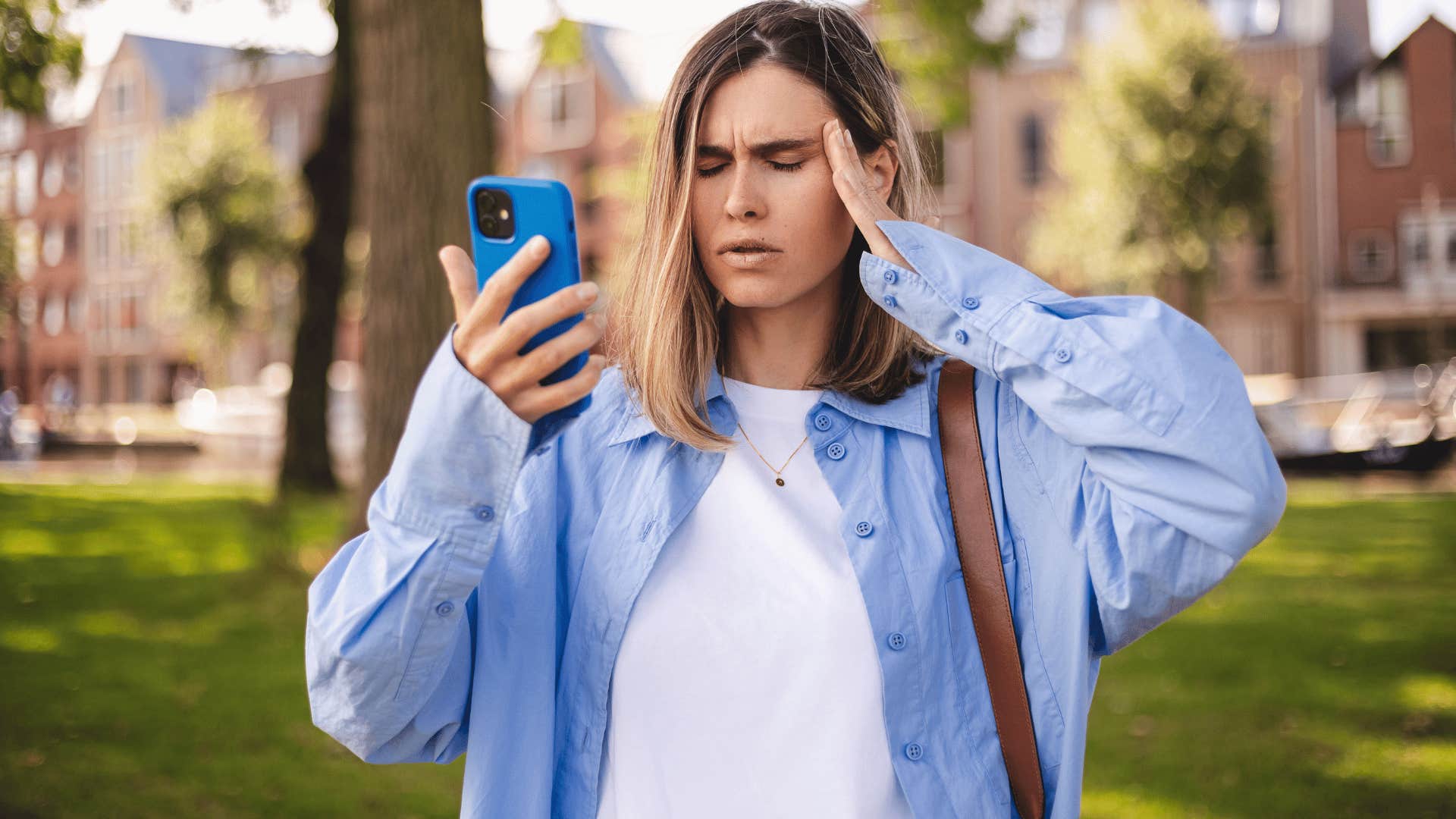 woman in white shirt staring at phone annoyed as she thinks i don't have the energy for this