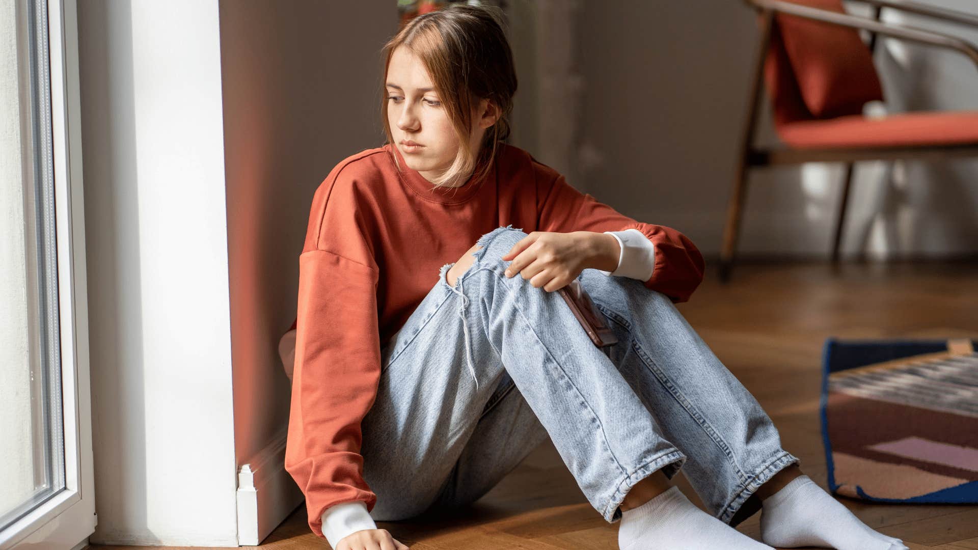 girl looking out window as she thinks she doesn't have energy for this