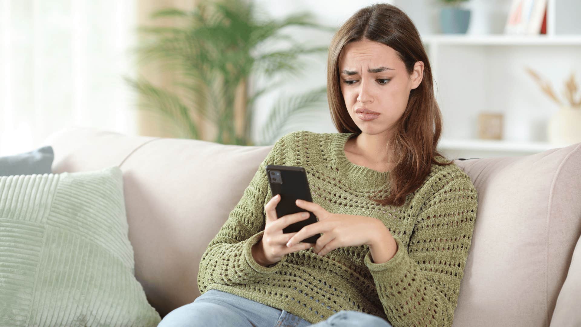 woman in green shirt on the phone disturbed as she thinks i don't even know what to say to that