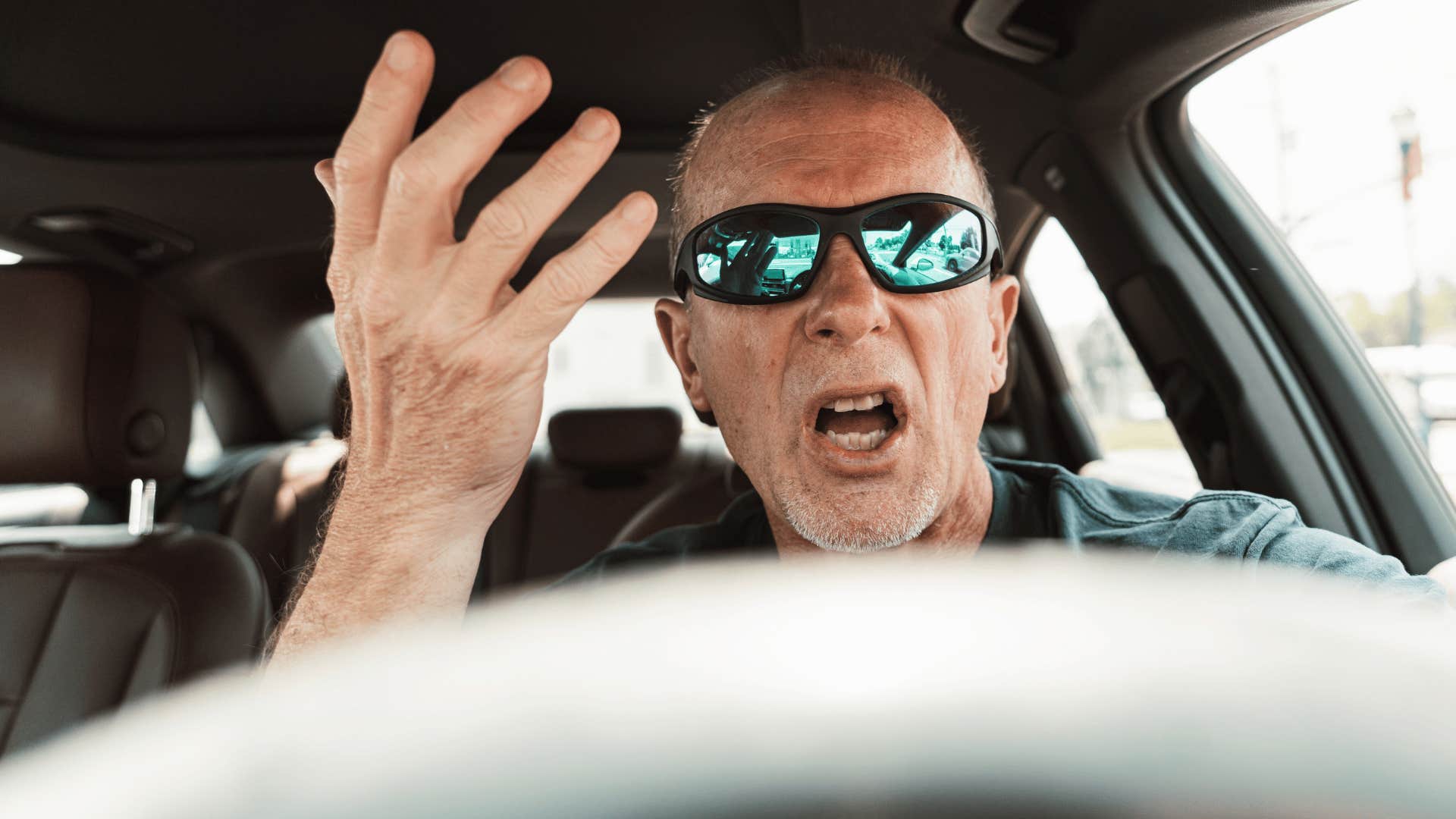 man upset in car as he screams use your common sense