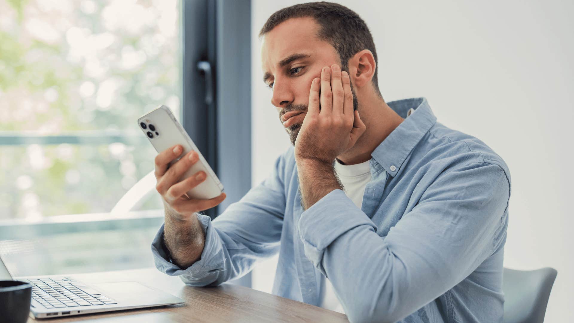 man in jean jacket staring at phone as he says there's nothing to look forward to