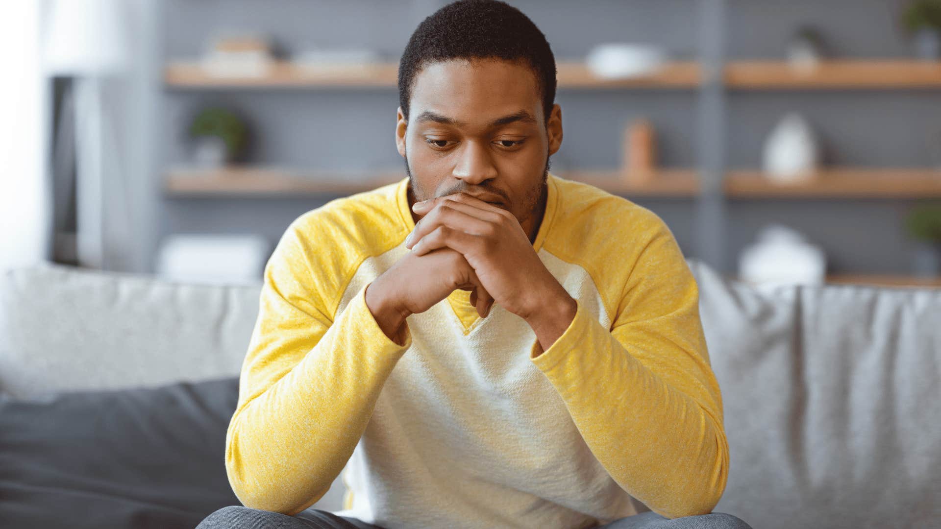man in yellow shirt thinking on couch i can't remember the last time i felt excited