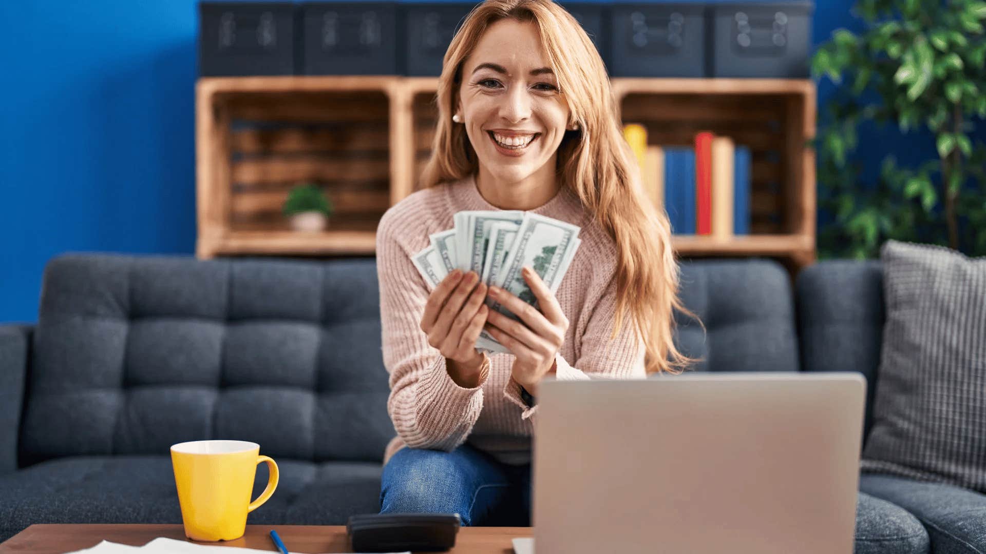 happy woman holding money in front of her face