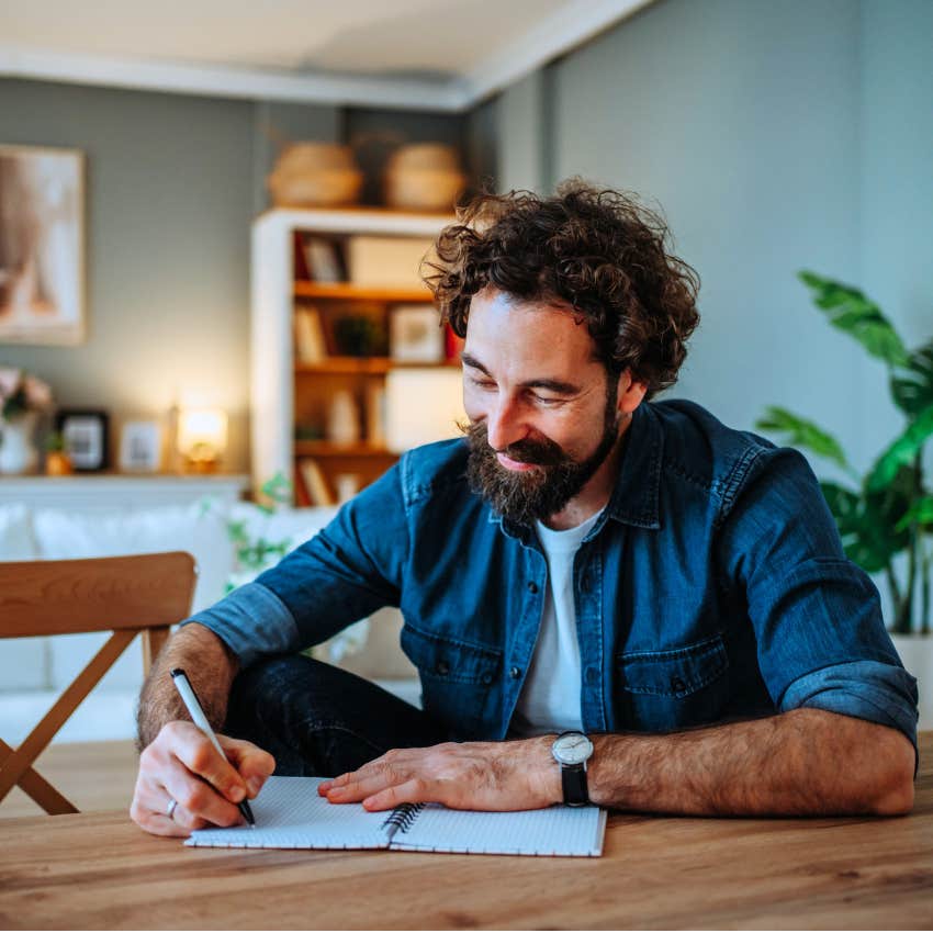 man writing in a journal to keep himself grounded