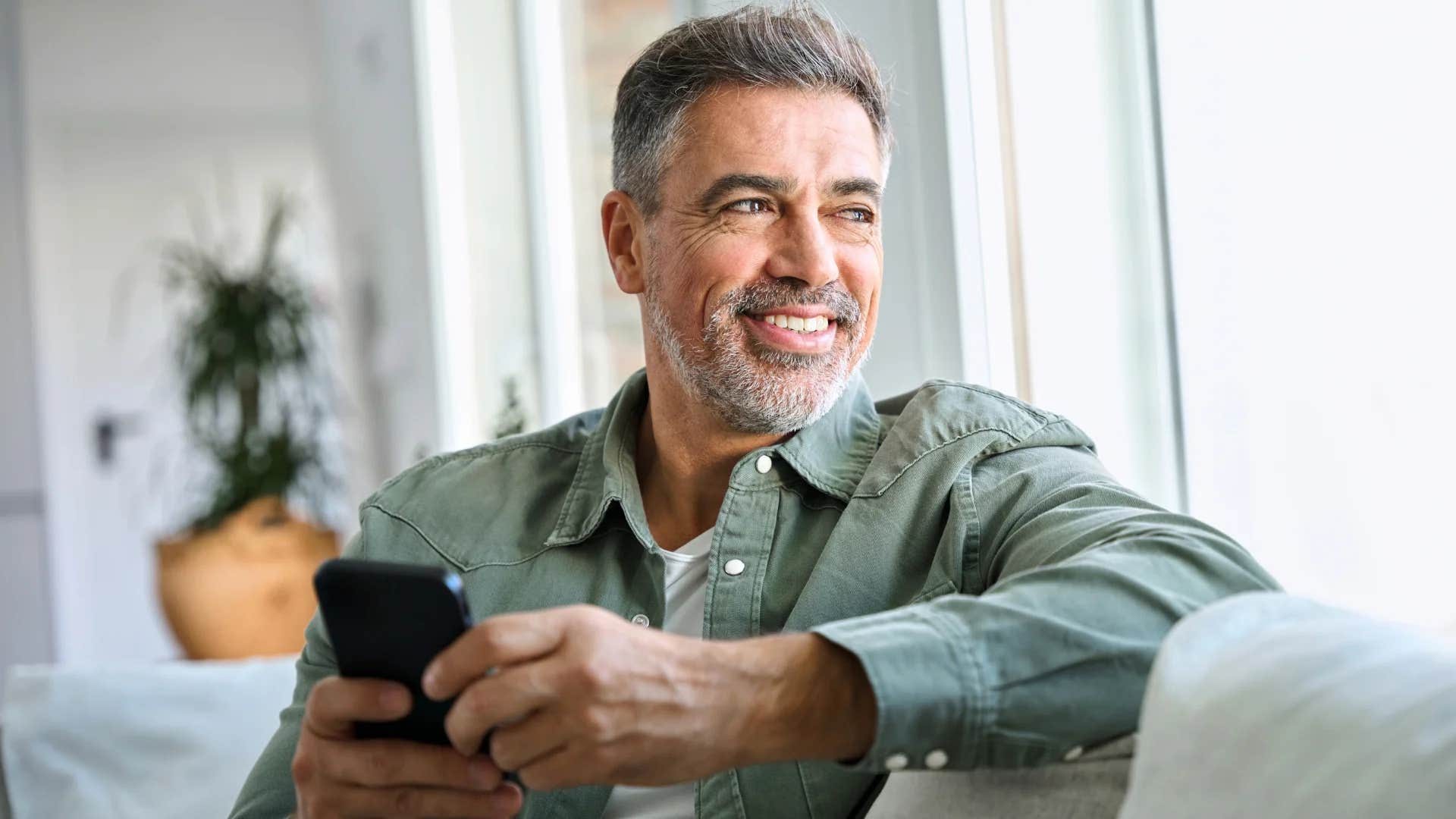 resilient man smiling and thinking at home