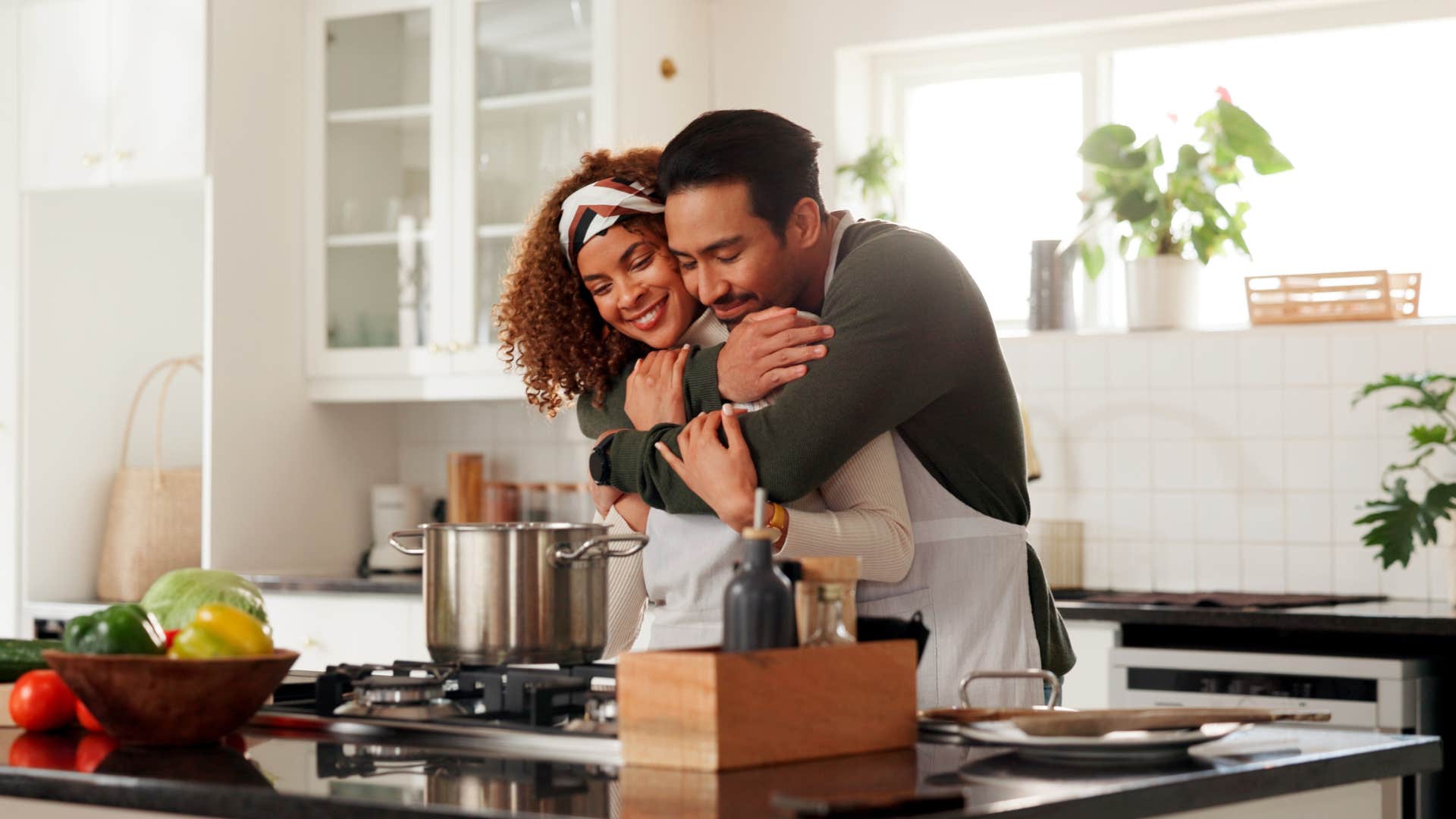 happily married husband hugging wife while she cooks dinner showing her respect
