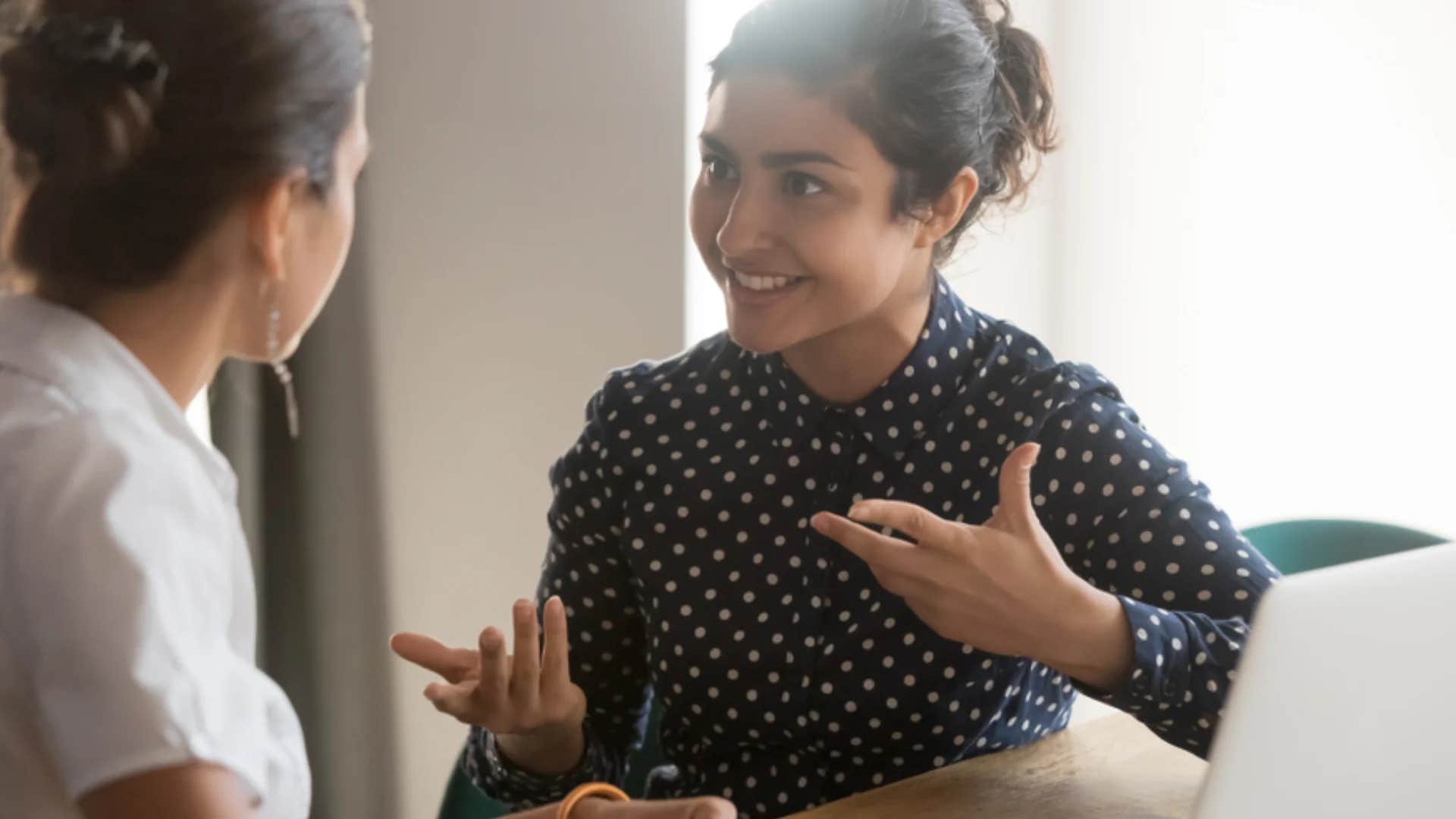 woman telling friend sometimes the writing really is on the wall