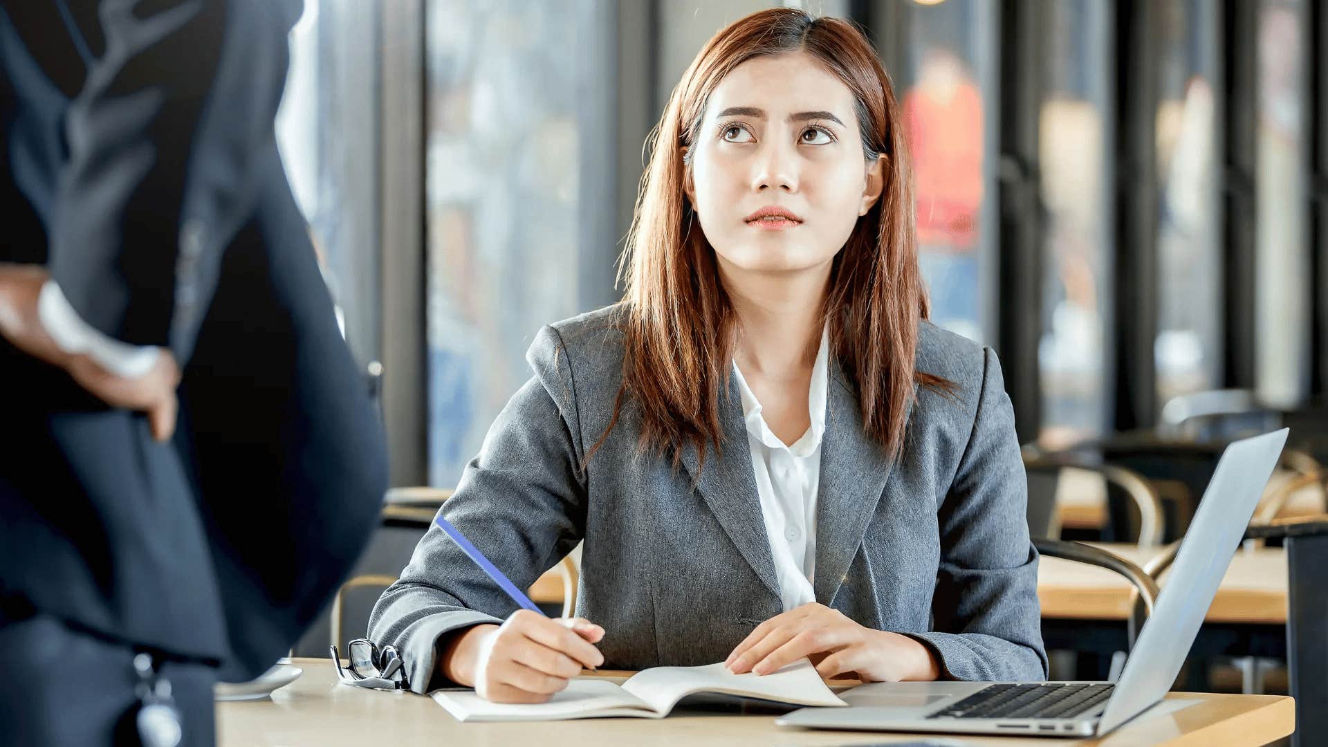 professional woman looking annoyed telling colleague that's not my job