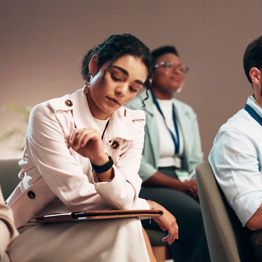 woman drained by work meetings looking at her watch feels like she has no time