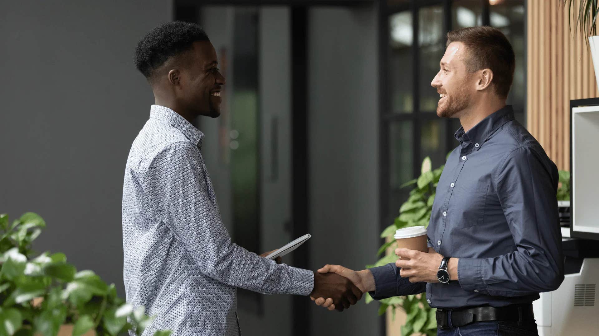 man who hates small talk shaking hands with co-worker telling him he doesn't want to monopolize his time