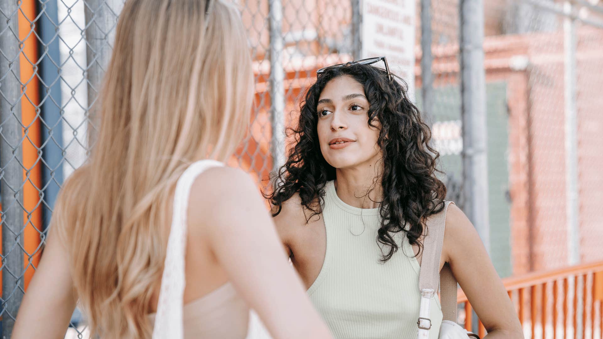 exhausted woman asking her friend to repeat something in conversation