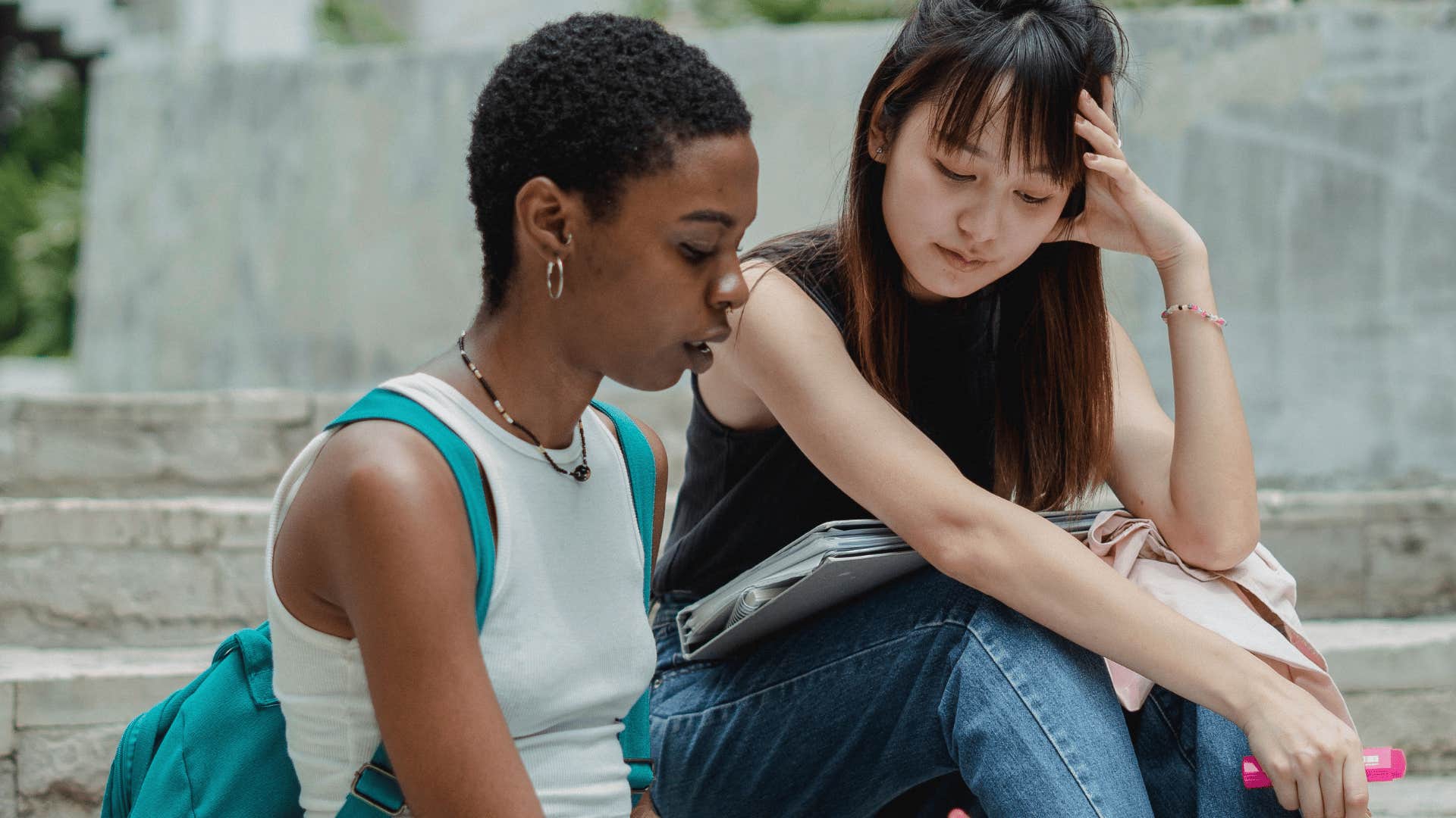 exhausted woman telling friend she's so bored while sitting outside