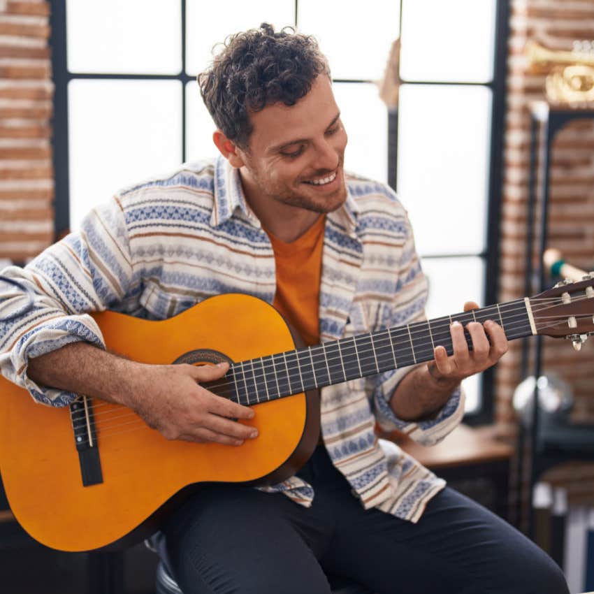 mentally and emotionally happy man enjoying his guitar playing hobby