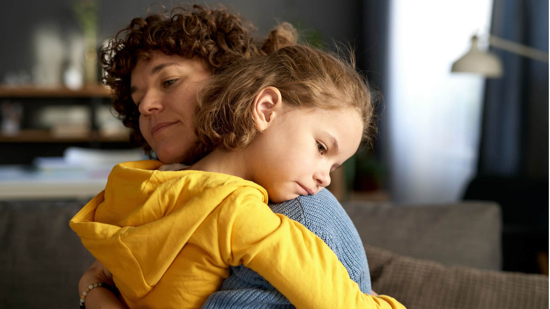 sad little girl hugging her tough mom who is teaching her how to handle her emotions