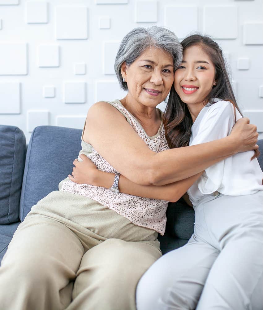 retired woman hugs her daughter at home 