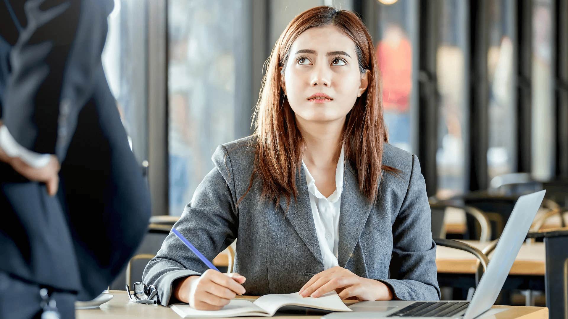irritable woman being underpaid talking to co-worker