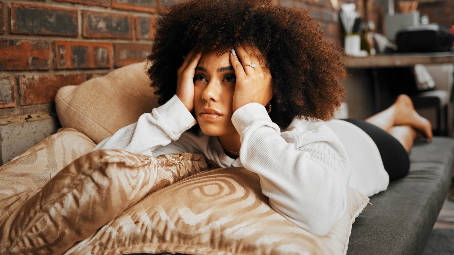 woman lying on couch would rather do anything than call her parents because she feels like she can't be herself around them