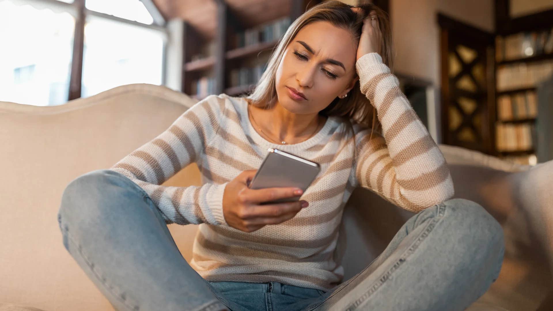woman looking at phone would rather do anything than call her parents because she doesn't feel heard when talking to them