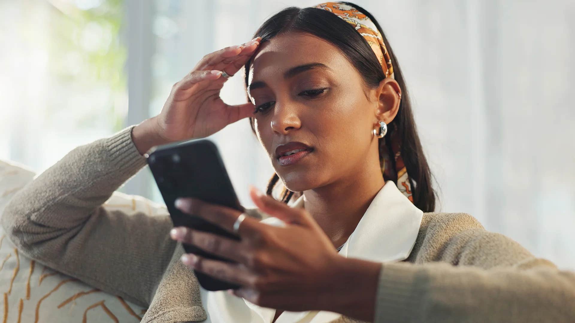 woman looking at phone would rather do anything than call her parents because they make her feel judged