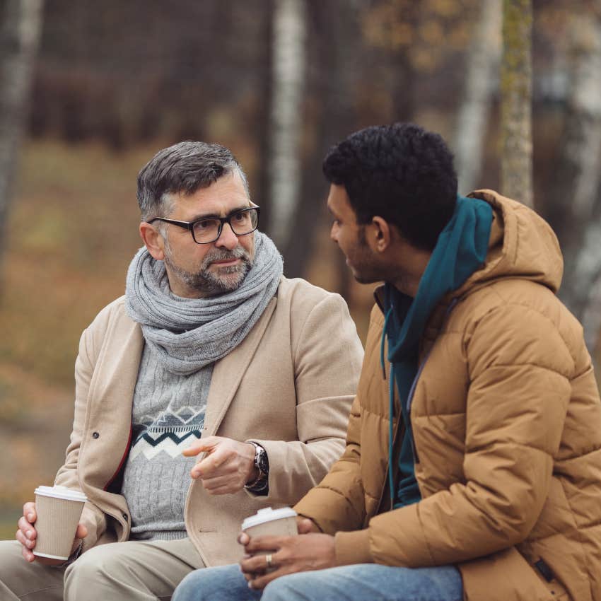 man talking to his friend on a park bench telling the same story because he is thoughtful