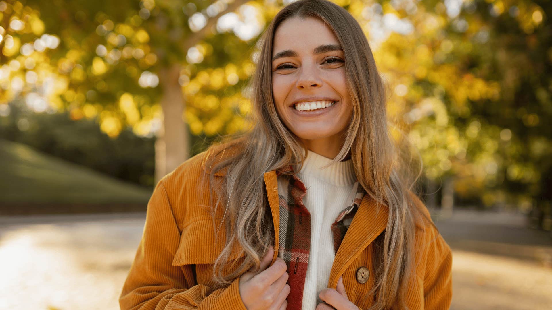 woman smiling brightly at camera as the universe gives her setbacks that show you just how strong she is