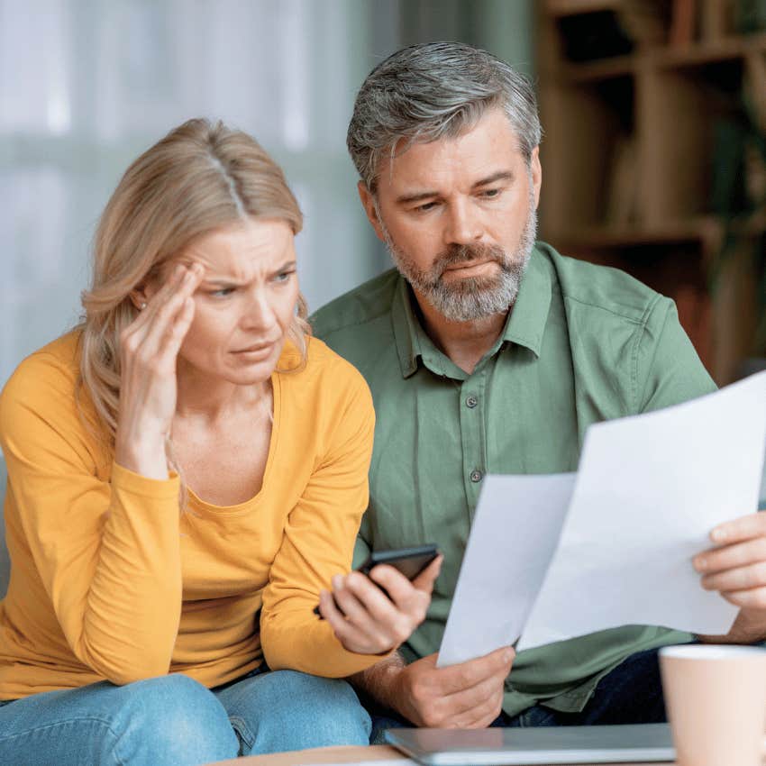 stressed gen-x couple looking down at paper