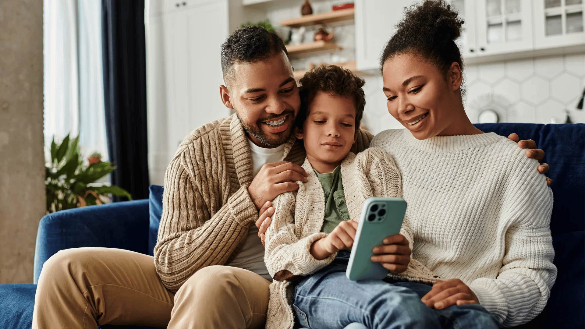 gen Z parents teaching their young child digital literacy on phone