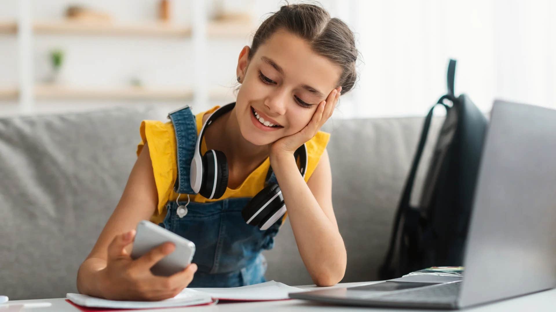 happy young girl looking at phone to communicate