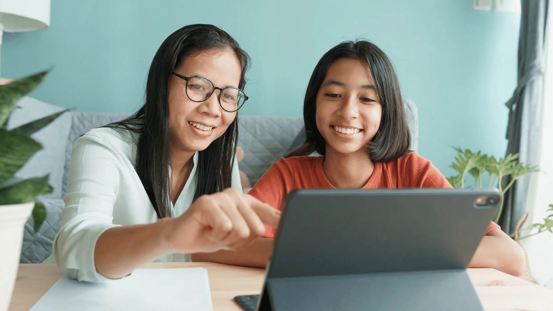 mom using ipad with daughter teaching her about work-life balance