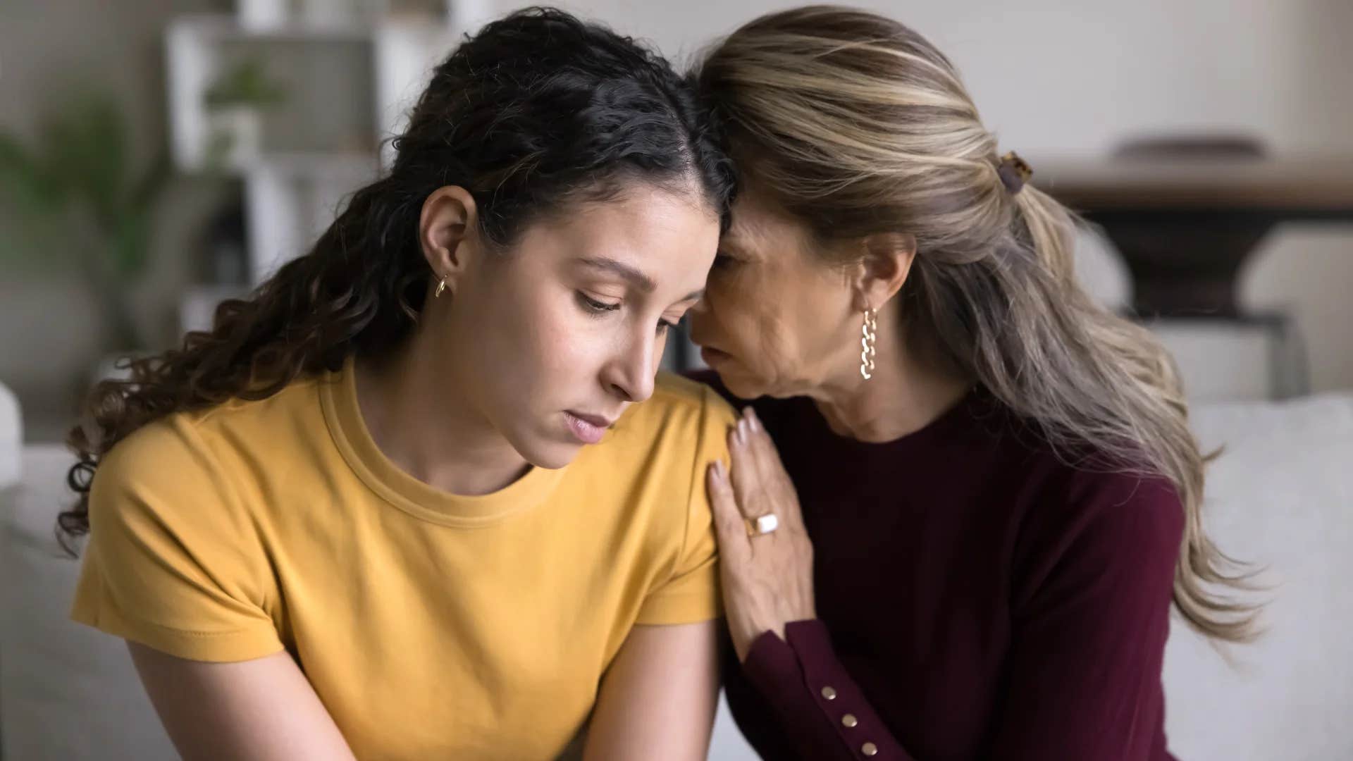 young woman feeling stressed leaning on mom for support