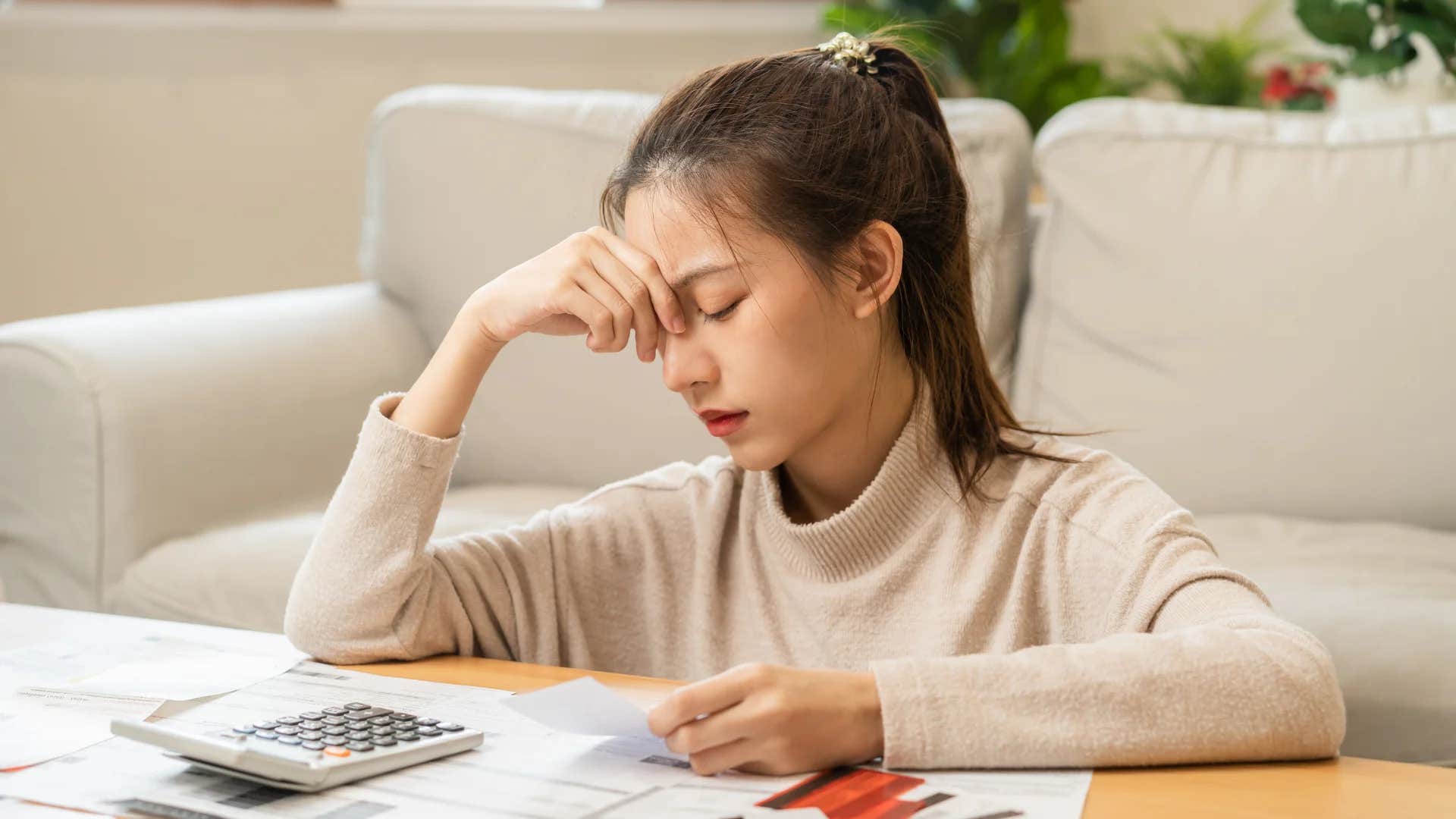 gen Z woman feeling anxious and stressed trying to pay bills