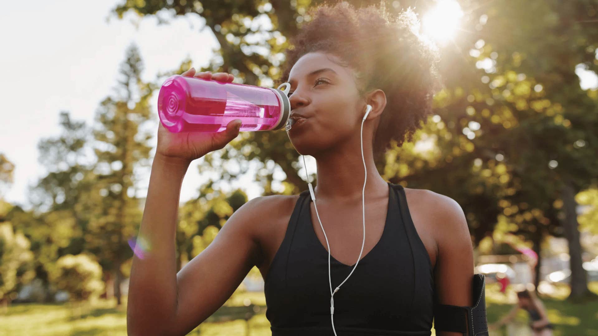 frugal woman drinking water from reusable bottle