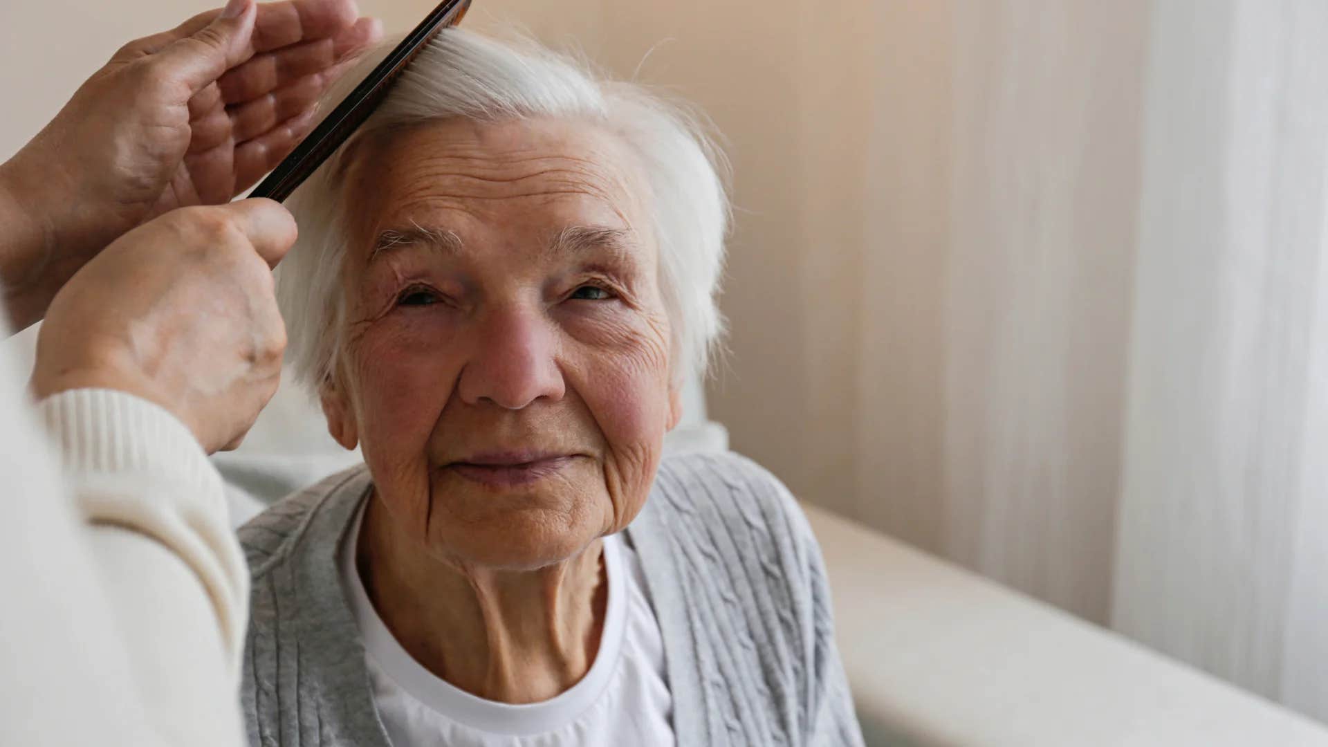 older woman having family member give her a free haircut