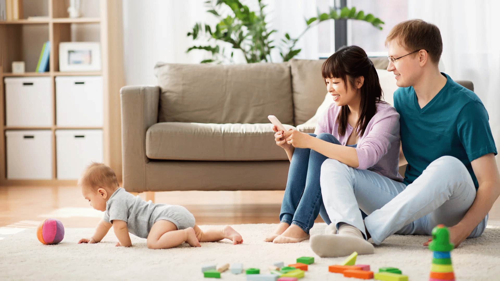 parents filming their baby crawling for the first time