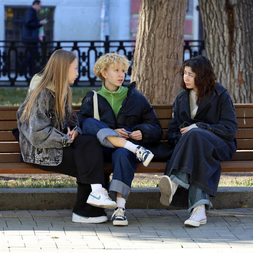 woman refuses to engage in small talk with two people on park bench