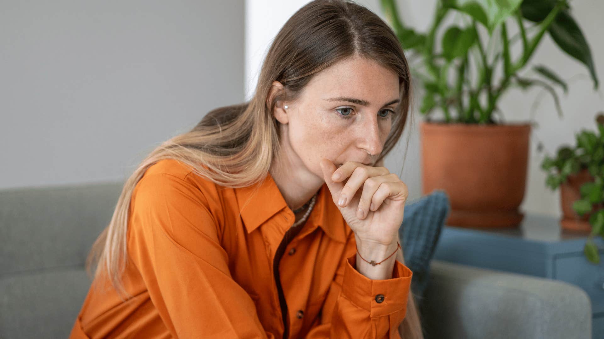 woman in orange shirt thinking deeply as she wonders when did their behavior start changing