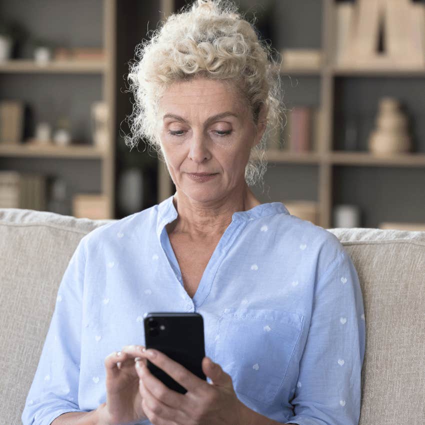 thoughtful older woman looking down at her phone