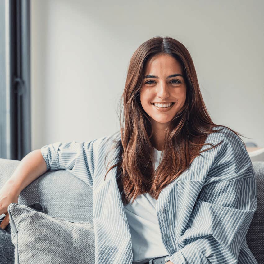 woman smiling and sitting on couch alone