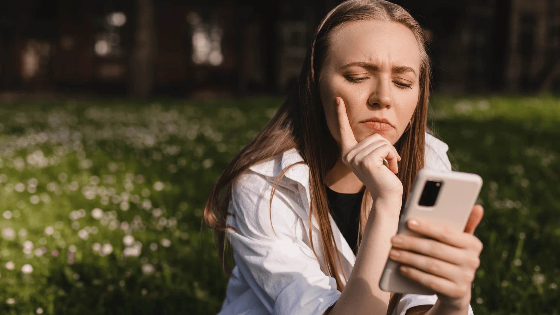 woman looking down at phone thinking you're not the center of my universe