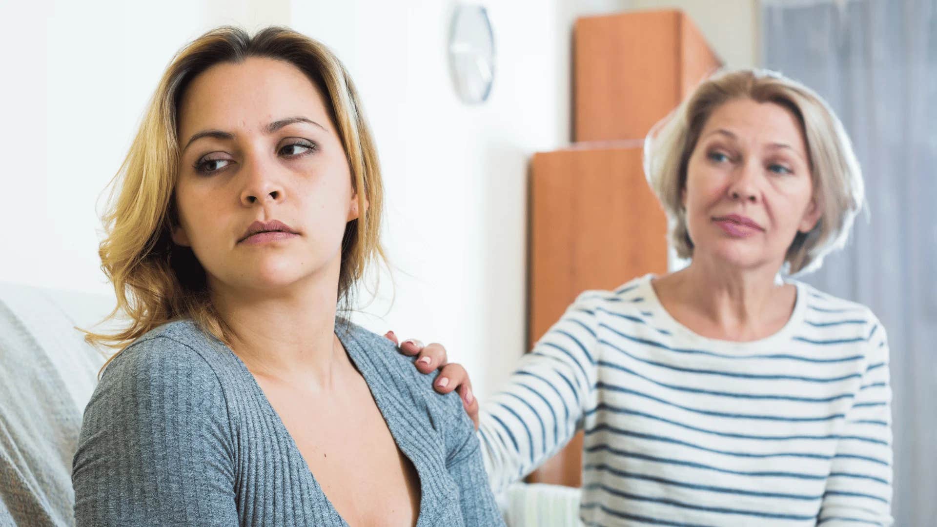 young woman turned away telling older woman she won't waste time fixing other people