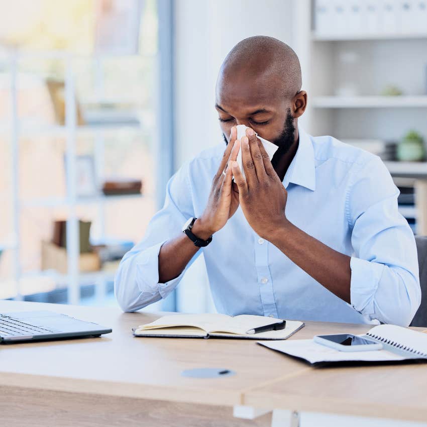 gen X man blowing his nose showing up to work sick