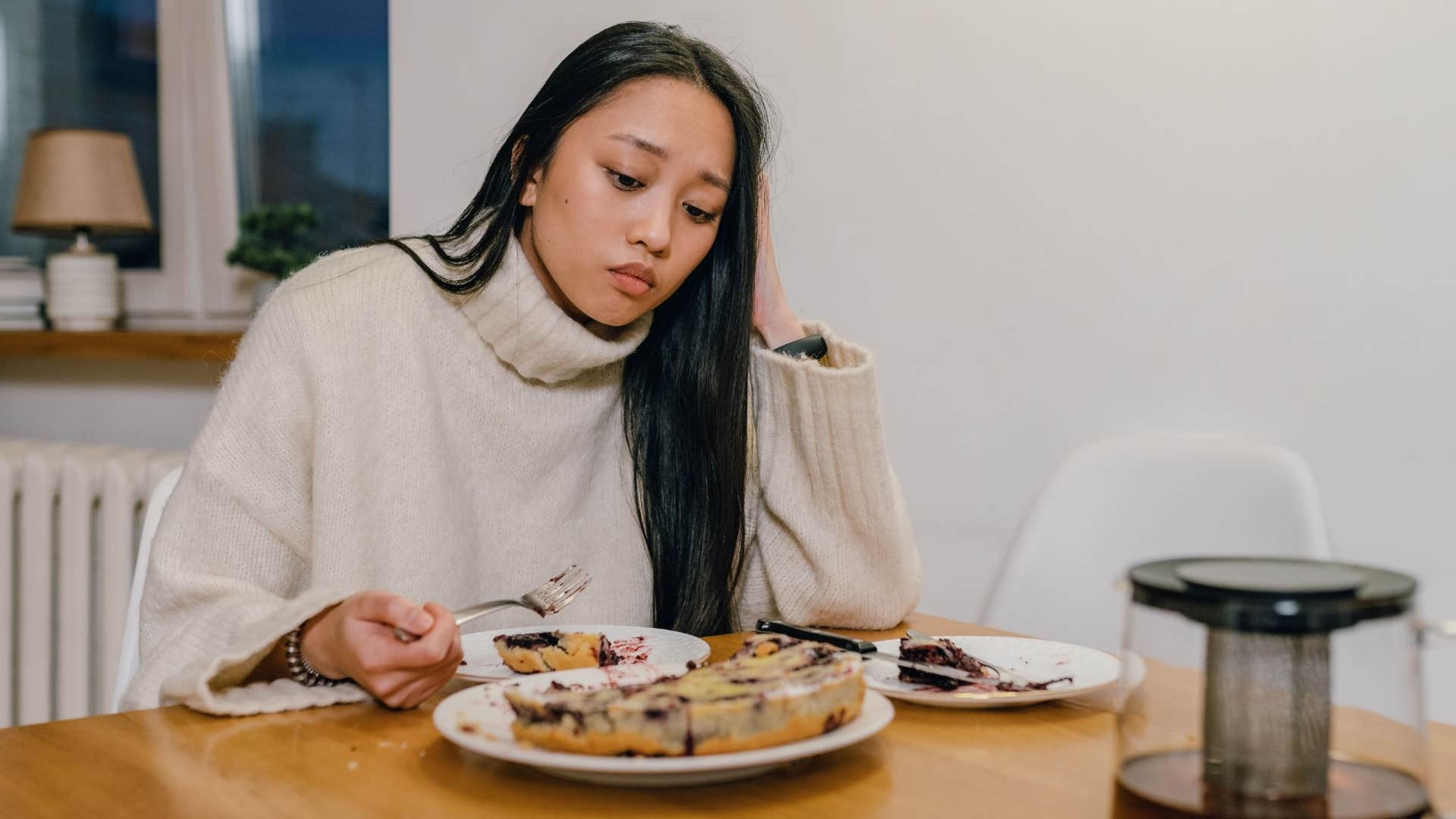 sad exhausted woman losing her appetite looking at food