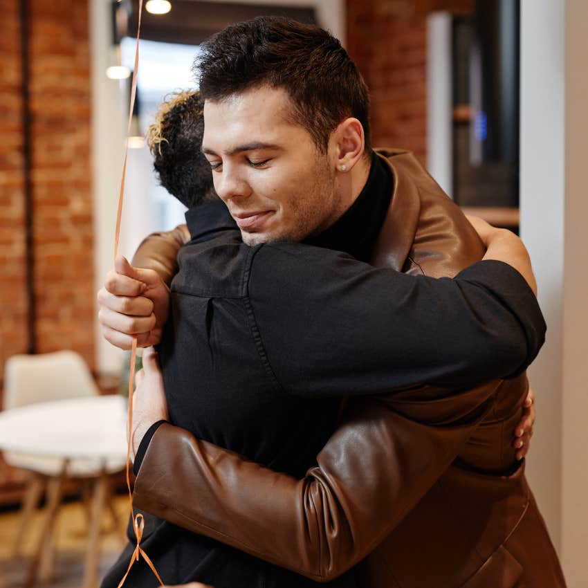 smiling co-workers hugging in the office