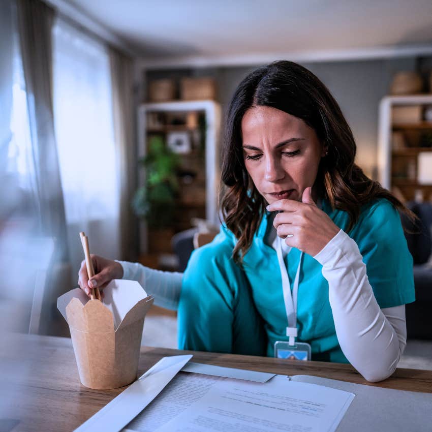 Woman still eating leftovers from a meal she disliked at home.
