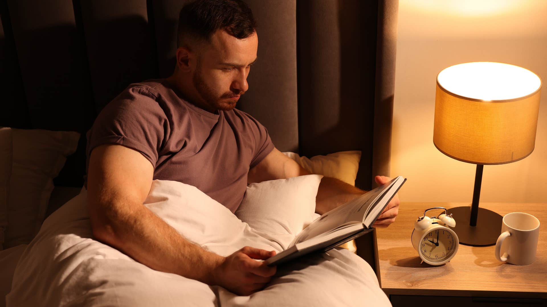 man reading a good book in bed as a comfort setting from childhood
